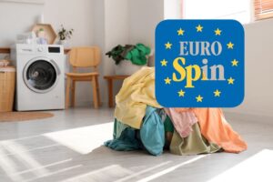 stanza con lavatrice, panni in terra e logo eurospin