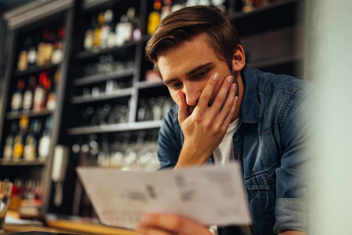 uomo preoccupato che legge un avviso